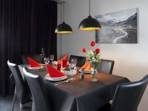 a dining room table with red napkins and chairs at Apartment Allod Park Haus C 307 by Interhome in Davos