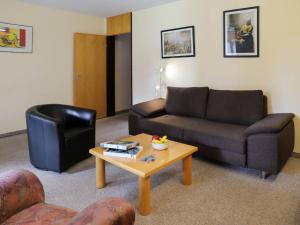 Apartment Allod Park Haus B E01 by Interhome في دافوس: غرفة معيشة مع أريكة وطاولة قهوة