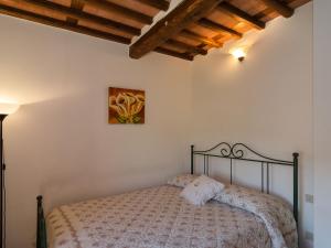 Sant' AlessioにあるHoliday Home Renata by Interhomeのベッドルーム1室(ベッド1台付)が備わります。壁には絵画が飾られています。