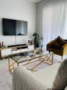 uma sala de estar com uma televisão de ecrã plano na parede em Apollo one bedroom em Sandton