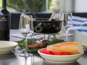 ダボスにあるApartment Mon Repos by Interhomeのワイングラス2杯と食べ物1杯付きテーブル