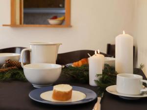a table with candles and a plate with a piece of cake at Apartment Allod Park Haus C 601 by Interhome in Davos +41 photos