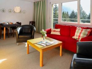 a living room with a red couch and a table at Apartment Allod Park Haus C 601 by Interhome in Davos