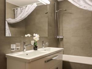 a bathroom with a sink and a mirror at Apartment Allod Park Haus C 601 by Interhome in Davos