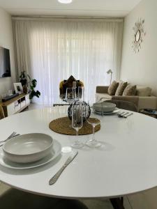 uma mesa branca com pratos e copos de vinho em Apollo one bedroom em Sandton