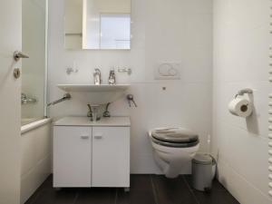 a white bathroom with a sink and a toilet at Apartment Mon Repos by Interhome in Davos