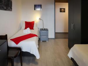 a bedroom with a bed with a red blanket on it at Apartment Allod Park Haus C 305 by Interhome in Davos