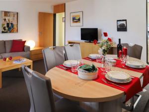 comedor con mesa y mantel rojo en Apartment Allod Park Haus C 603 by Interhome, en Davos
