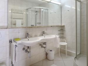 een witte badkamer met een wastafel en een douche bij Apartment Allod-Park-50 by Interhome in Davos