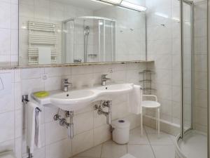 Un baño blanco con lavabo y ducha. en Apartment Allod Park Haus C 603 by Interhome, en Davos