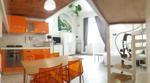 ローマにあるTermini Loftのキッチン(オレンジ色のキャビネット、テーブル、椅子付)