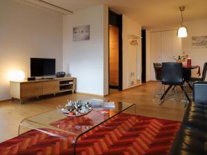 a living room with a glass table and a television at Apartment Allod Park Haus C 705 by Interhome in Davos