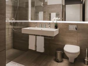 a bathroom with a sink and a toilet at Apartment Allod Park Haus C 705 by Interhome in Davos