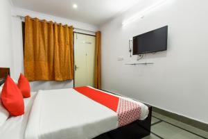 a bedroom with a bed and a flat screen tv at Flagship Sitar Guest House in Rudrapur