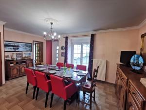 jadalnia ze stołem i czerwonymi krzesłami w obiekcie Holiday Home La Grève by Interhome w mieście Cherrueix