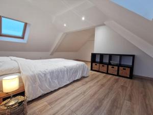 sypialnia z białym łóżkiem i drewnianą podłogą w obiekcie Holiday Home La Grève by Interhome w mieście Cherrueix