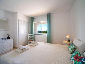 a bedroom with a bed with two towels on it at Apartment Quinta Girassol-6 by Interhome in Loulé