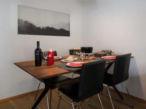 a dining room table with two chairs and a bottle of wine at Apartment Allod Park Haus C 707 by Interhome in Davos