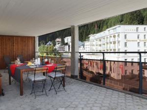 uma varanda com uma mesa e cadeiras e vista para um edifício em Apartment Allod Park Haus C 707 by Interhome em Davos