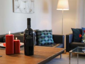 uma garrafa de vinho sentada numa mesa com duas velas em Apartment Allod Park Haus C 707 by Interhome em Davos