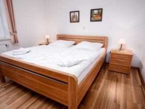 ノルトダイヒにあるApartment Westerriede by Interhomeのベッドルーム1室(白いシーツを使用した大きな木製ベッド1台付)