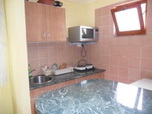 a kitchen with a counter and a sink and a tv at Emese Apartman in Hajdúszoboszló +20 photos