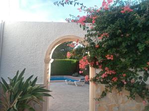 Balcon del Mar的住宿－Holiday Home Amaranda by Interhome，通往带粉红色花卉的庭院的拱门