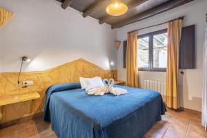 1 dormitorio con 1 cama azul y 2 toallas en Turismo Rural & SPA El Cercado en Bérchules