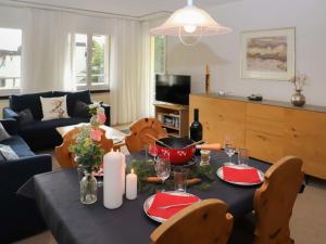 a living room with a table with red plates and candles at Apartment Allod-Park-39 by Interhome in Davos