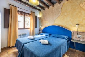a bedroom with two beds with blue sheets at Turismo Rural & SPA El Cercado in Bérchules