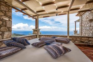 Habitación con balcón y cama grande con almohadas. en Villa Armos, en Skinária