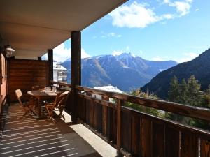 balcón con mesa, sillas y montañas en Apartment Les Chalets de Marie A 22 by Interhome en Ovronnaz