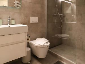 ein Bad mit einer Dusche, einem WC und einem Waschbecken in der Unterkunft Apartment Allod Park Haus C 202 by Interhome in Davos