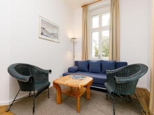 uma sala de estar com um sofá azul e duas cadeiras em Apartment Zinnowitzer Hof-5 by Interhome em Zinnowitz