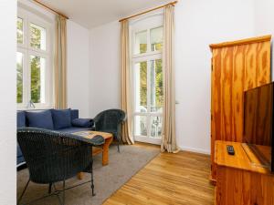 ein Wohnzimmer mit einem Sofa und einem TV in der Unterkunft Apartment Zinnowitzer Hof-5 by Interhome in Zinnowitz