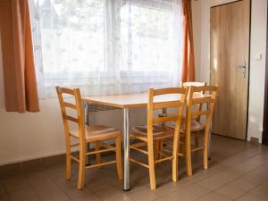 a dining room table with four chairs and a window at Holiday Home Kemp Stříbrný rybník-1 by Interhome in Hradec Králové