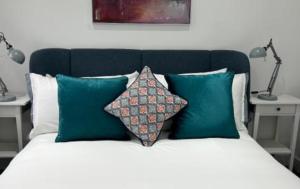 ミッチャムにあるLondon Stunning Three Bedroom Houseのベッド(緑と白の枕、ランプ2つ付)