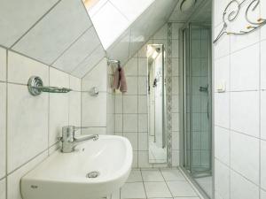 a white bathroom with a sink and a shower at Apartment Melchien 2 by Interhome in Zinnowitz