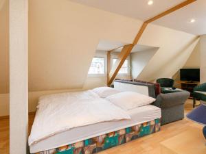 a bedroom with a bed and a couch and a chair at Apartment Melchien 2 by Interhome in Zinnowitz