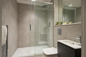 a bathroom with a shower and a toilet and a sink at Chancery Lane by Viridian Apartments in London