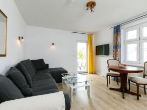 a living room with a black couch and a table at Apartment Melchien 1 by Interhome in Zinnowitz