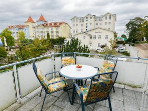 a table and chairs on a balcony with buildings at Apartment Melchien 1 by Interhome in Zinnowitz
