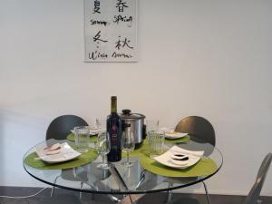 a glass table with a bottle of wine and glasses at Apartment Torre Tessuti Apt-Stefano by Interhome in Locarno
