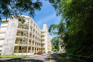 an apartment building on a street with cars parked at EE's Summer House - Homestay 3 min walk to beach in Batu Ferringhi