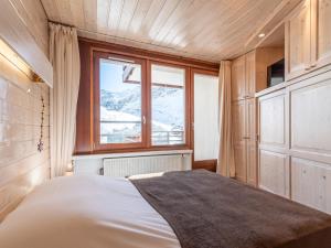 a bedroom with a bed and a large window at Apartment Le Curling B - Val Claret-41 by Interhome in Tignes