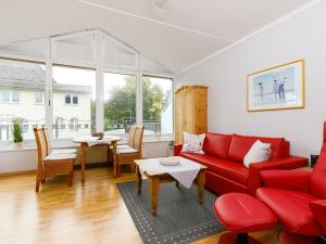Una sala de estar con un sofá rojo y una mesa. en Apartment Luise von Preußen - App- 205 by Interhome, en Zinnowitz