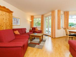 una sala de estar con sofás rojos y una mesa. en Apartment Luise von Preußen-4 by Interhome, en Zinnowitz