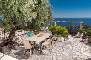 un tavolo e sedie su un patio con vista sull'oceano di Villa Armos a Skinária