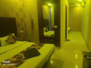 Habitación de hotel con 2 camas y espejo en Sohan guest house en Chandigarh