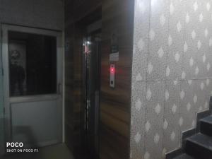 um elevador com uma luz vermelha ao lado de uma porta em Sohan guest house em Chandīgarh